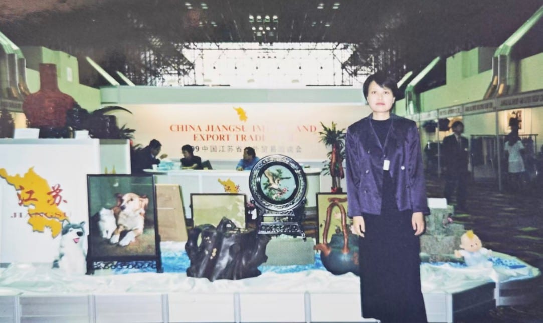 Amanda Yan, age 26, standing in front of the 'China Jiangsu Import and Export Trade Fair' booth in New York, 1999.